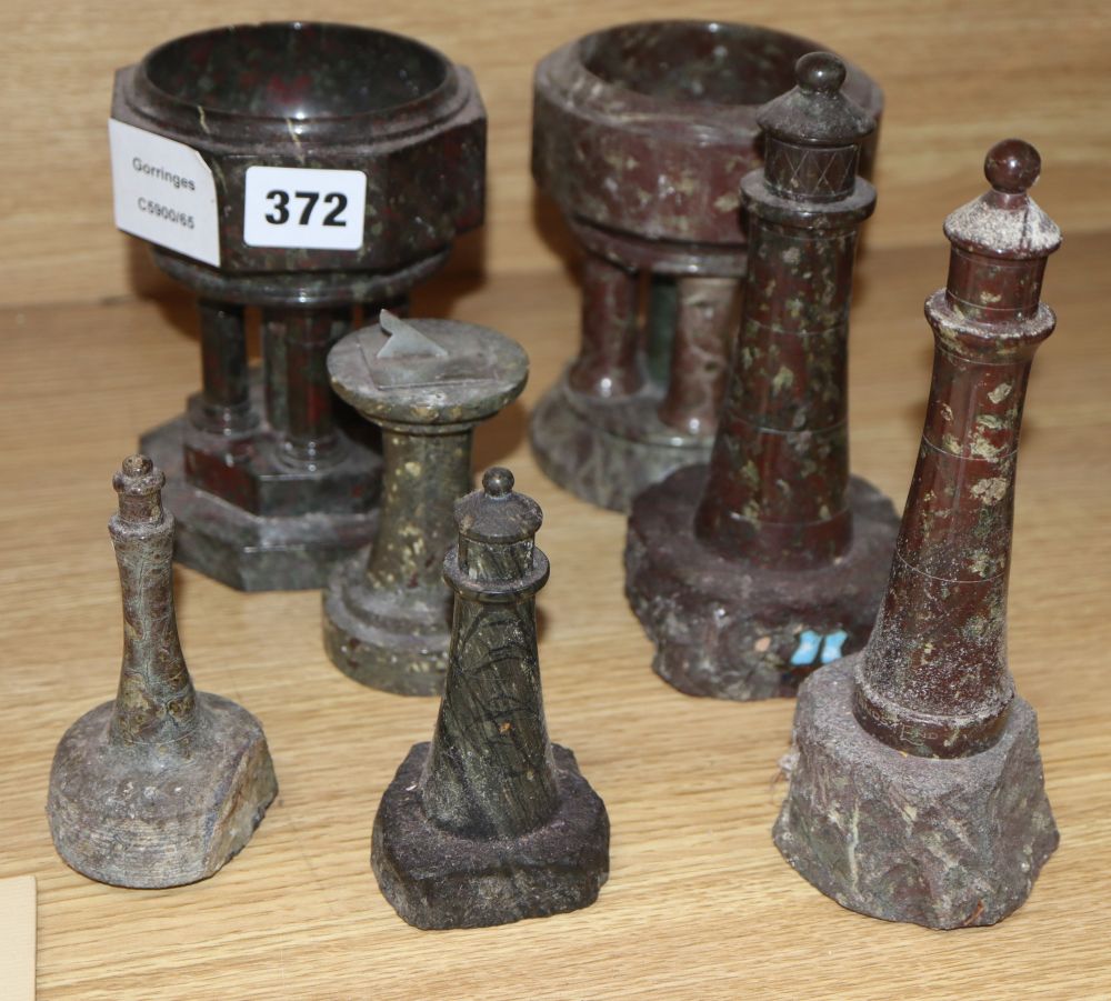 Cornish serpentine models of two fonts, four lighthouses and a sundial, tallest 18cm